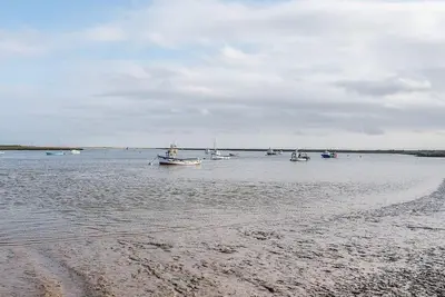 a group of boats in the water on a beach at The Little House, Orford in Woodbridge