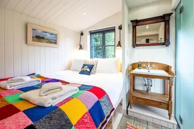 a small bedroom with a bed and a sink at The Little House, Orford in Woodbridge