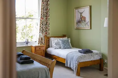 a bedroom with two beds and a window at Saham Grove Hall by Group Retreats in West Bradenham