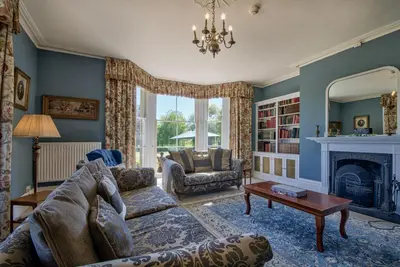a living room with a couch and a fireplace at Saham Grove Hall by Group Retreats in West Bradenham