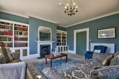 a living room with a couch and a fireplace at Saham Grove Hall by Group Retreats in West Bradenham