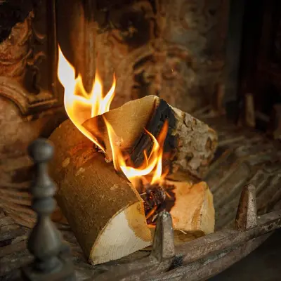 a fire is burning in a stone oven at Saham Grove Hall by Group Retreats in West Bradenham