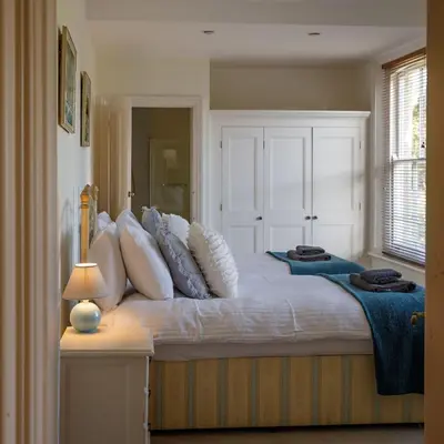 a bedroom with a large bed with white pillows at Saham Grove Hall by Group Retreats in West Bradenham