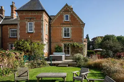 a house with a table and chairs in the yard at Saham Grove Hall by Group Retreats in West Bradenham