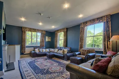 a living room with couches and a fireplace at Saham Grove Hall by Group Retreats in West Bradenham