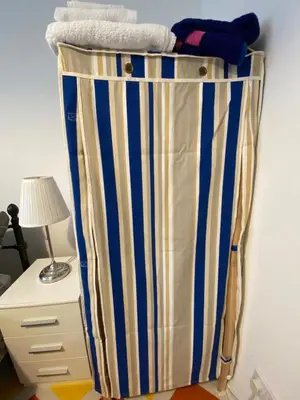 a room with a bed with blue and white stripes at Jmk home in Lexden