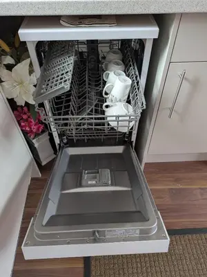 a dishwasher with a sink and dishes in it at Colchester Town, modern, detached, guest house in Colchester