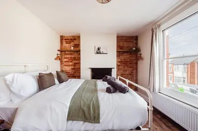 a bedroom with a large bed and a fireplace at Host & Stay - Sherrington Road Abode in Ipswich