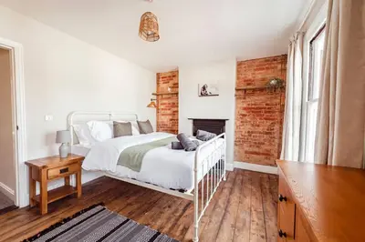 a bedroom with a white bed and a brick wall at Host & Stay - Sherrington Road Abode in Ipswich