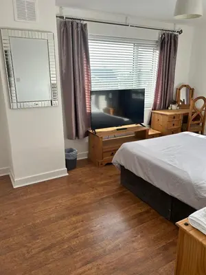 a bedroom with a bed and a flat screen tv at The Poacher in Stevenage