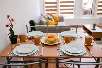 a table with plates and utensils and bread on it at Host & Stay - Maple Court in Ipswich