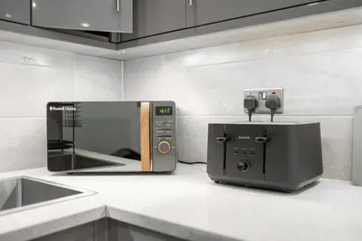 a microwave sitting on a counter next to a toaster oven at Host & Stay - Maple Court in Ipswich