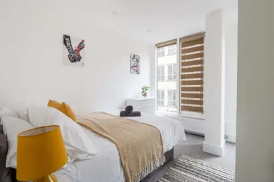 a white bedroom with a bed and a window at Host & Stay - Maple Court in Ipswich