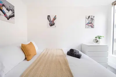 a bedroom with a bed with white walls and a window at Host & Stay - Maple Court in Ipswich