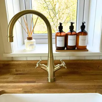 a sink with three bottles on a window sill at Greenacre Lodge - cosy, dog-friendly rural home with private garden in Redgrave