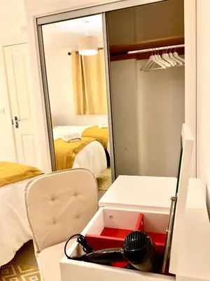 a mirror in a room with a bed and a closet at Ocean-homestay in Colchester