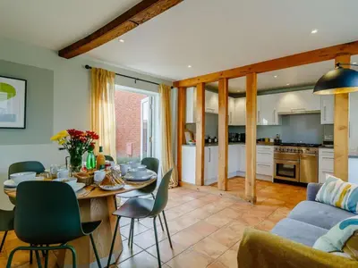 a kitchen and living room with a table and a couch at 3 Bed in Saxmundham oc-89691 in Aldringham