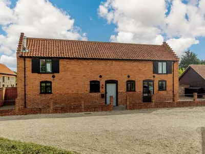 a brick house with a white door on a street at 3 Bed in Saxmundham oc-89691 in Aldringham