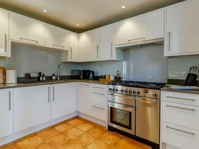 a kitchen with white cabinets and a stainless steel oven at 3 Bed in Saxmundham oc-89691 in Aldringham