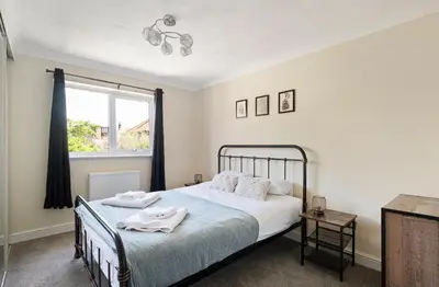 a bedroom with a bed and a window at Spacious & Elegant 3BR Home Near Ipswich City Centre in Ipswich