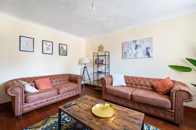 a living room with two couches and a coffee table at Spacious & Elegant 3BR Home Near Ipswich City Centre in Ipswich