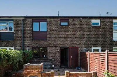 a brick building with a red door in front at Spacious & Elegant 3BR Home Near Ipswich City Centre in Ipswich