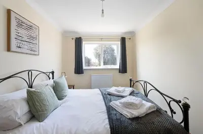 a bedroom with a bed with two towels on it at Spacious & Elegant 3BR Home Near Ipswich City Centre in Ipswich