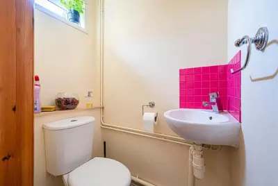 a bathroom with a white toilet and a sink at Spacious & Elegant 3BR Home Near Ipswich City Centre in Ipswich