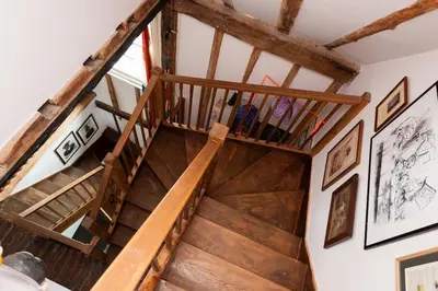 a wooden staircase in a room with wooden beams at Charming Tudor riverside house in Wivenhoe