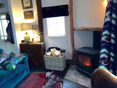 a living room with a blue couch and a fireplace at Charming Tudor riverside house in Wivenhoe