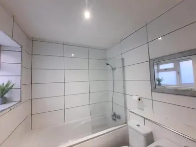 a white bathroom with a tub and a toilet at Colchester 3-Beds Sleeps 5 with Parking & WiFi in Colchester