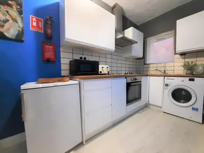 a kitchen with white cabinets and a washer and dryer at Colchester 3-Beds Sleeps 5 with Parking & WiFi in Colchester