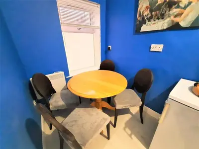 a table and chairs in a room with a blue wall at Colchester 3-Beds Sleeps 5 with Parking & WiFi in Colchester