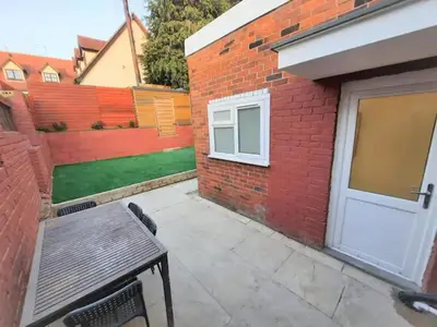 a patio with a bench and a brick building at Colchester 3-Beds Sleeps 5 with Parking & WiFi in Colchester