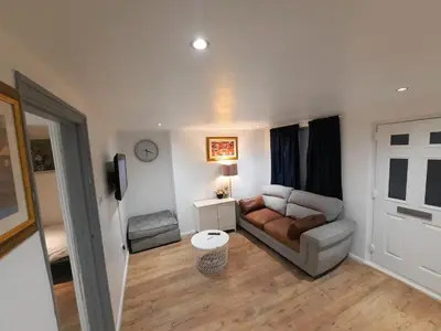 a living room with a couch and a table at Colchester 3-Beds Sleeps 5 with Parking & WiFi in Colchester