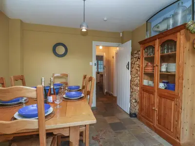 a dining room with a table with blue dishes on it at 6 The Whinlands in Leiston