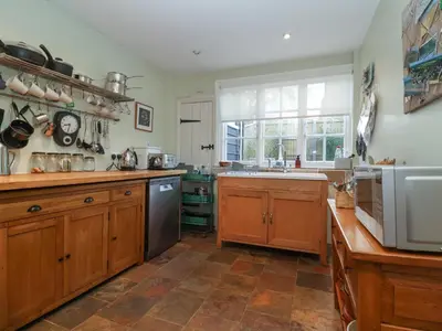 a kitchen with wooden cabinets and a large window at 6 The Whinlands in Leiston