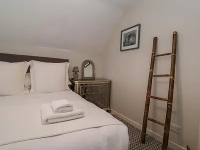 a bedroom with a bed with two towels on it at 6 The Whinlands in Leiston