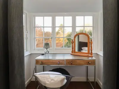 a mirror on a dresser in a room with a window at 6 The Whinlands in Leiston