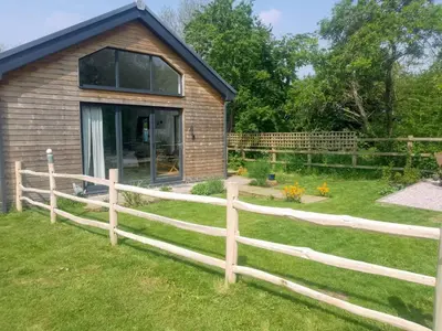a wooden fence in front of a house at Bluebell Annexe in Little Grandsen