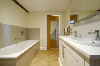 a bathroom with two sinks and a bath tub at Upper Barn - a large family house by Aldeburgh Coastal Cottages in Ufford