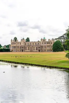 a large building with a lake in front of it at Guest House in Audley End in Saffron Walden