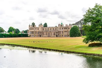 a large castle with a lake in front of it at Guest House in Audley End in Saffron Walden