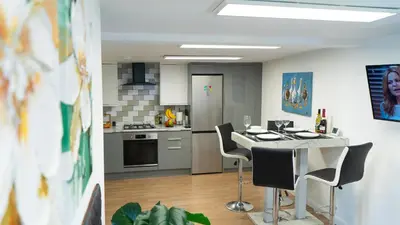 a kitchen with a table and chairs in a room at Exquisite 1-bedroom apartment with on-site parking in Braintree