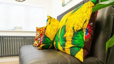 a couch with two colorful pillows on it at Exquisite 1-bedroom apartment with on-site parking in Braintree