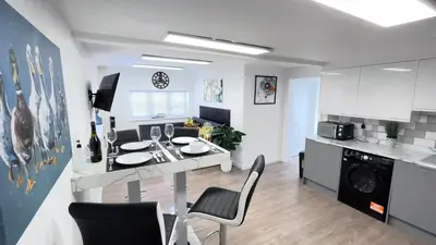 a kitchen and living room with a table and chairs at Exquisite 1-bedroom apartment with on-site parking in Braintree
