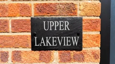 a sign on a brick wall with the wordupper leakage at Exquisite 1-bedroom apartment with on-site parking in Braintree