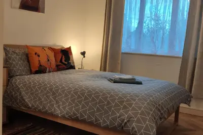 a bed with a gray comforter and a window at Apartment - Sleeps 4 - Parking - WiFi in Colchester