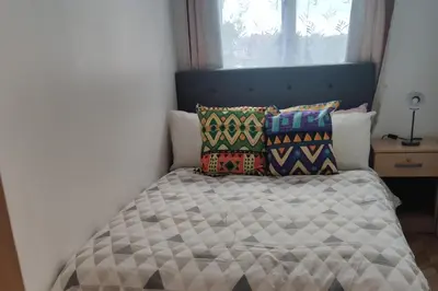 a bedroom with a bed with a blue headboard and pillows at Apartment - Sleeps 4 - Parking - WiFi in Colchester