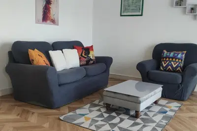 a living room with two blue couches and a coffee table at Apartment - Sleeps 4 - Parking - WiFi in Colchester